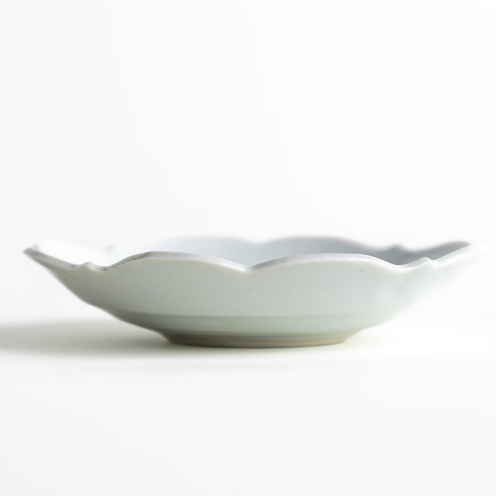 A small ceramic plate with a cloud-like shape, featuring a smooth white finish.