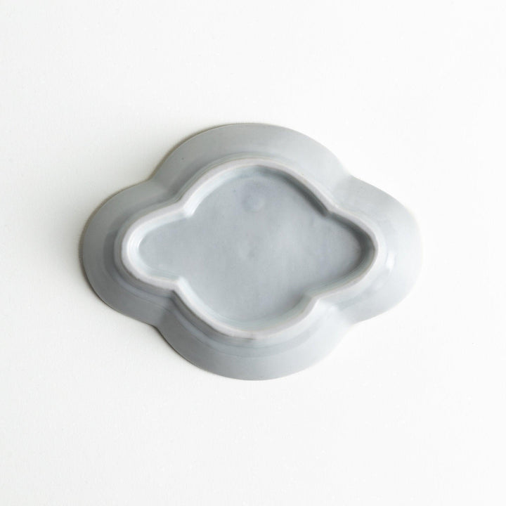 A small, white, quince-shaped ceramic plate with a smooth finish.