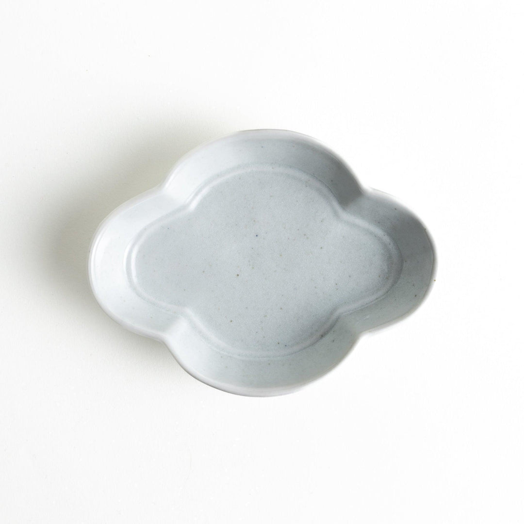 A small, white, quince-shaped ceramic plate with a smooth finish.