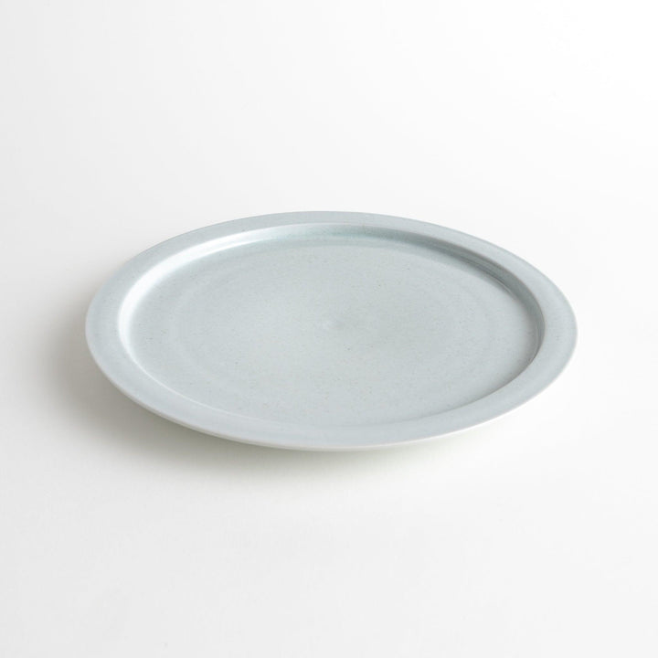 A large round ceramic plate with a clean, minimalist design and a slightly raised edge.