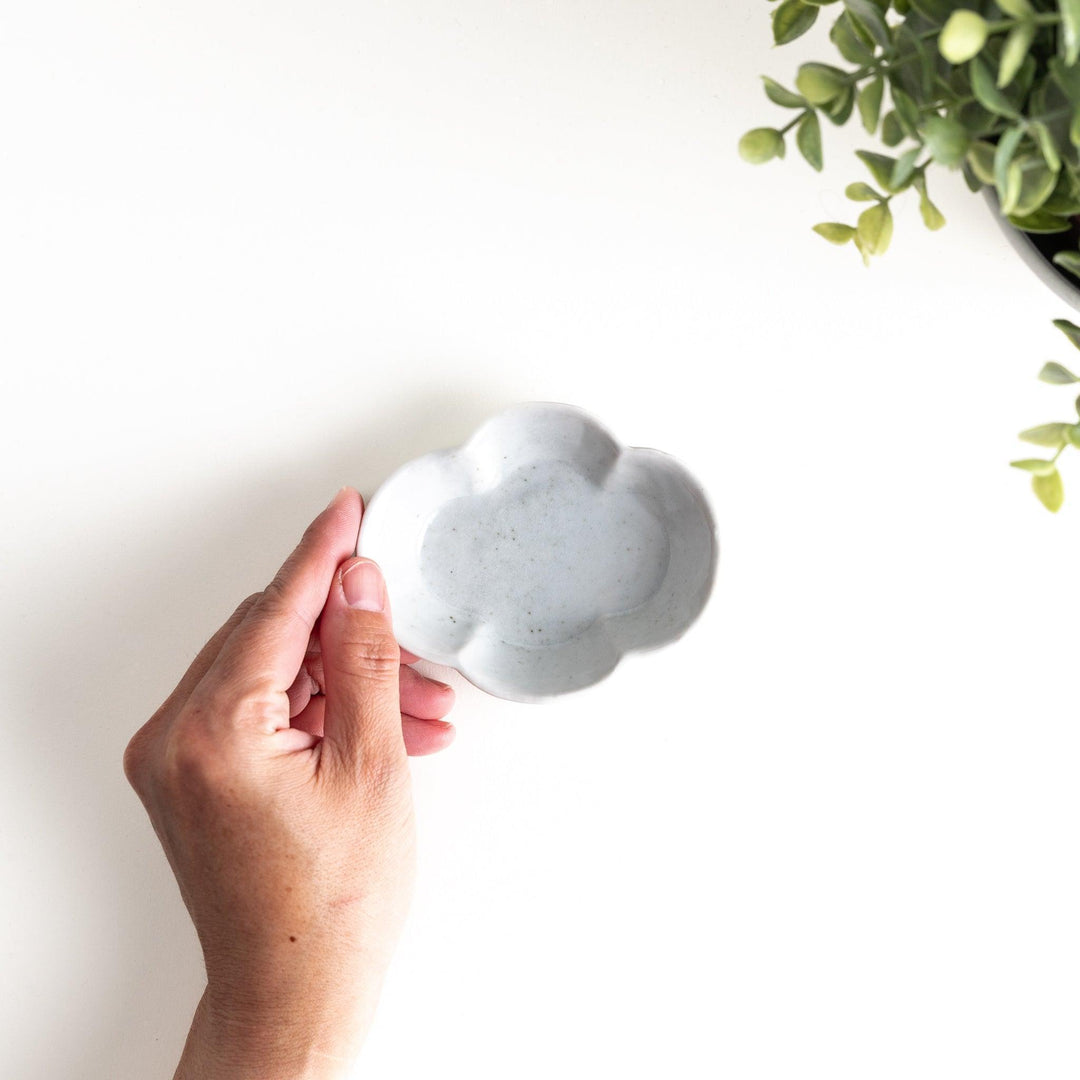 A small ceramic plate shaped like a quince, with a smooth white finish.