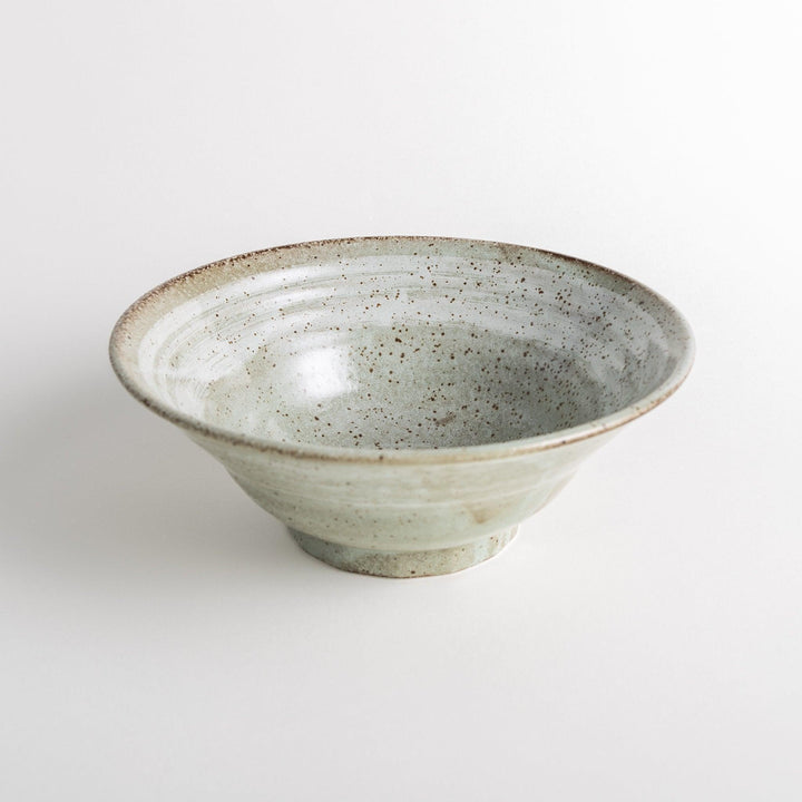 A light gray, wide-rimmed bowl with a textured and speckled surface.