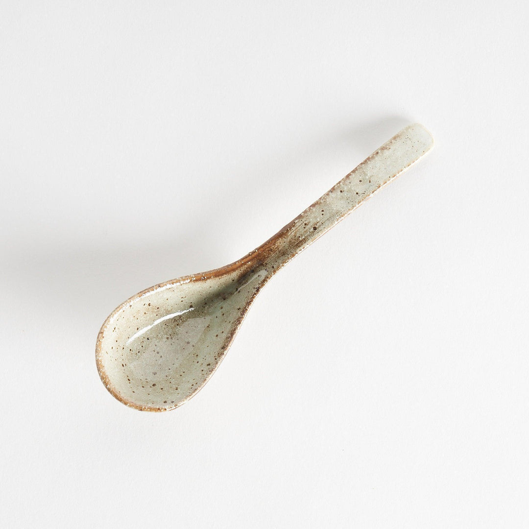 A matching light gray, textured and speckled ceramic spoon.