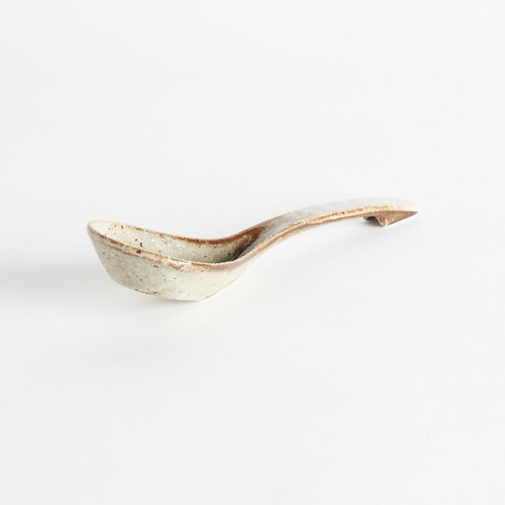 A matching light gray, textured and speckled ceramic spoon.