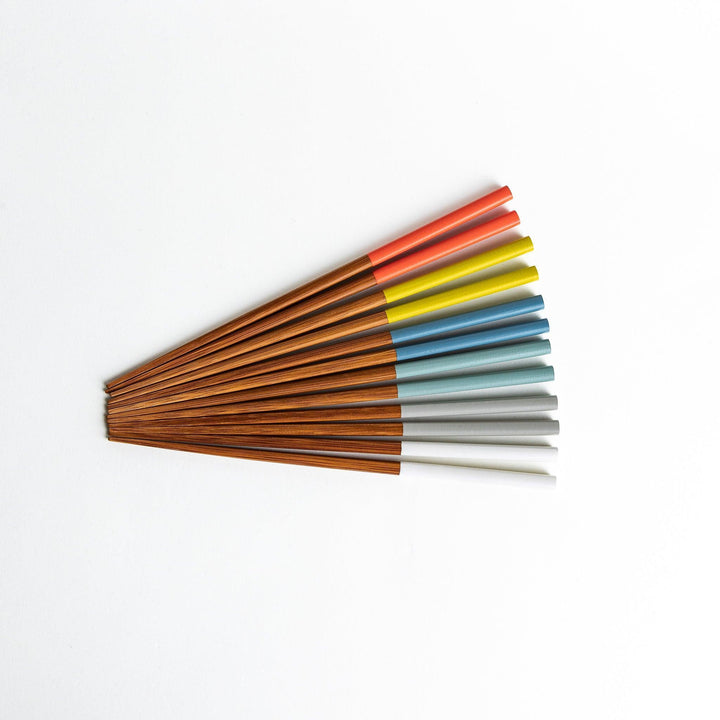 A set of wooden chopsticks with vibrant colored tops in various shades, including yellow, blue, orange, green, and white.