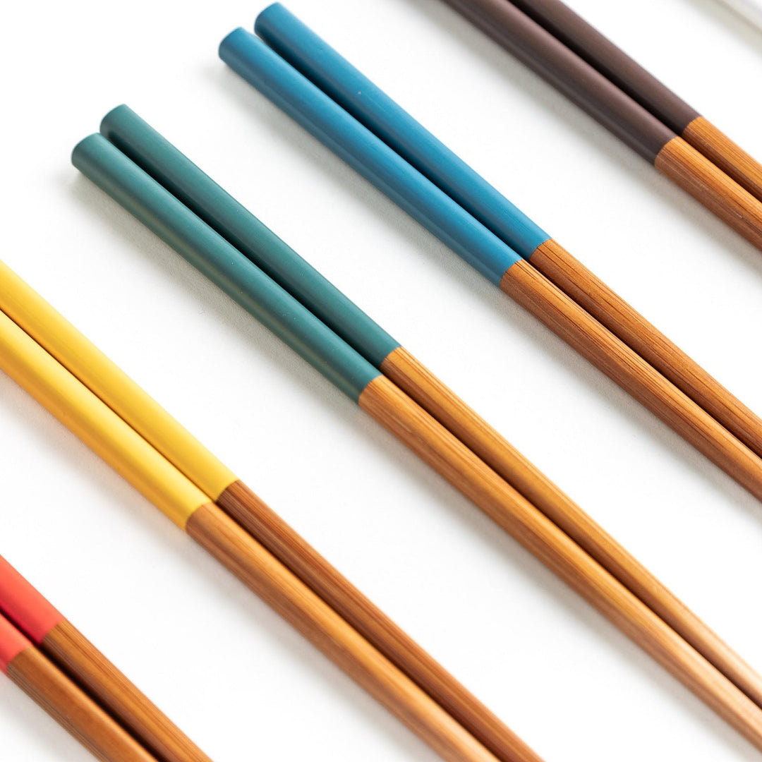 A set of wooden chopsticks with vibrant colored tops in various shades, including yellow, blue, orange, green, and white.