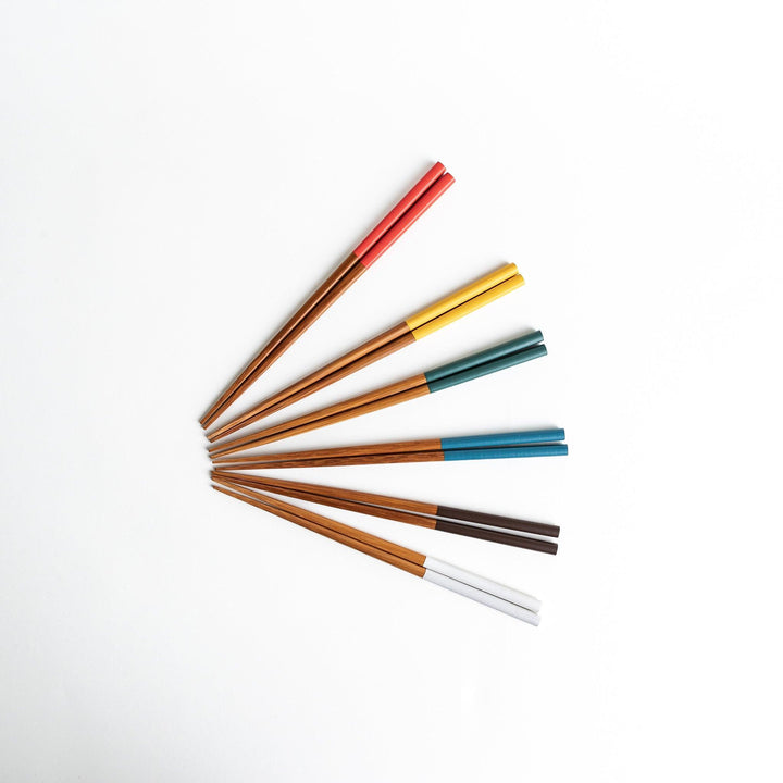 A set of wooden chopsticks with vibrant colored tops in various shades, including yellow, blue, orange, green, and white.