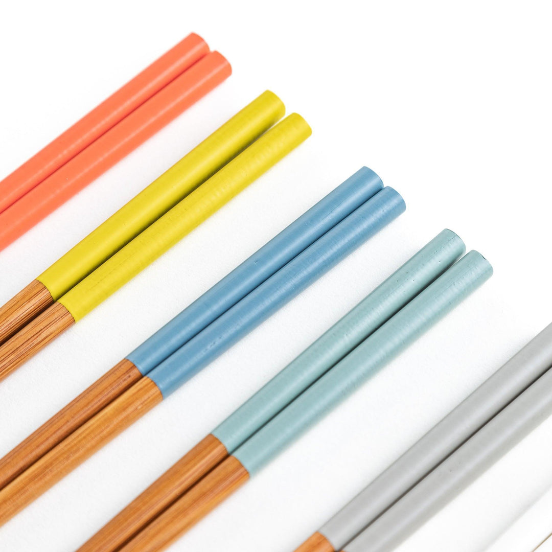 A set of wooden chopsticks with vibrant colored tops in various shades, including yellow, blue, orange, green, and white.