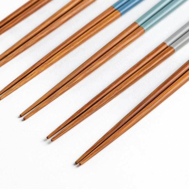 A set of wooden chopsticks with vibrant colored tops in various shades, including yellow, blue, orange, green, and white.