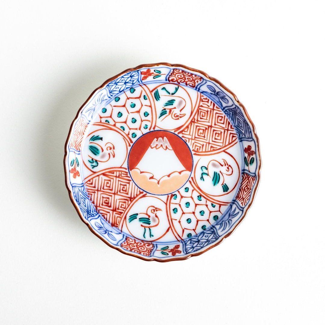 A vibrant ceramic dish with intricate patterns in blue, red, and green, centering around a depiction of Mount Fuji.