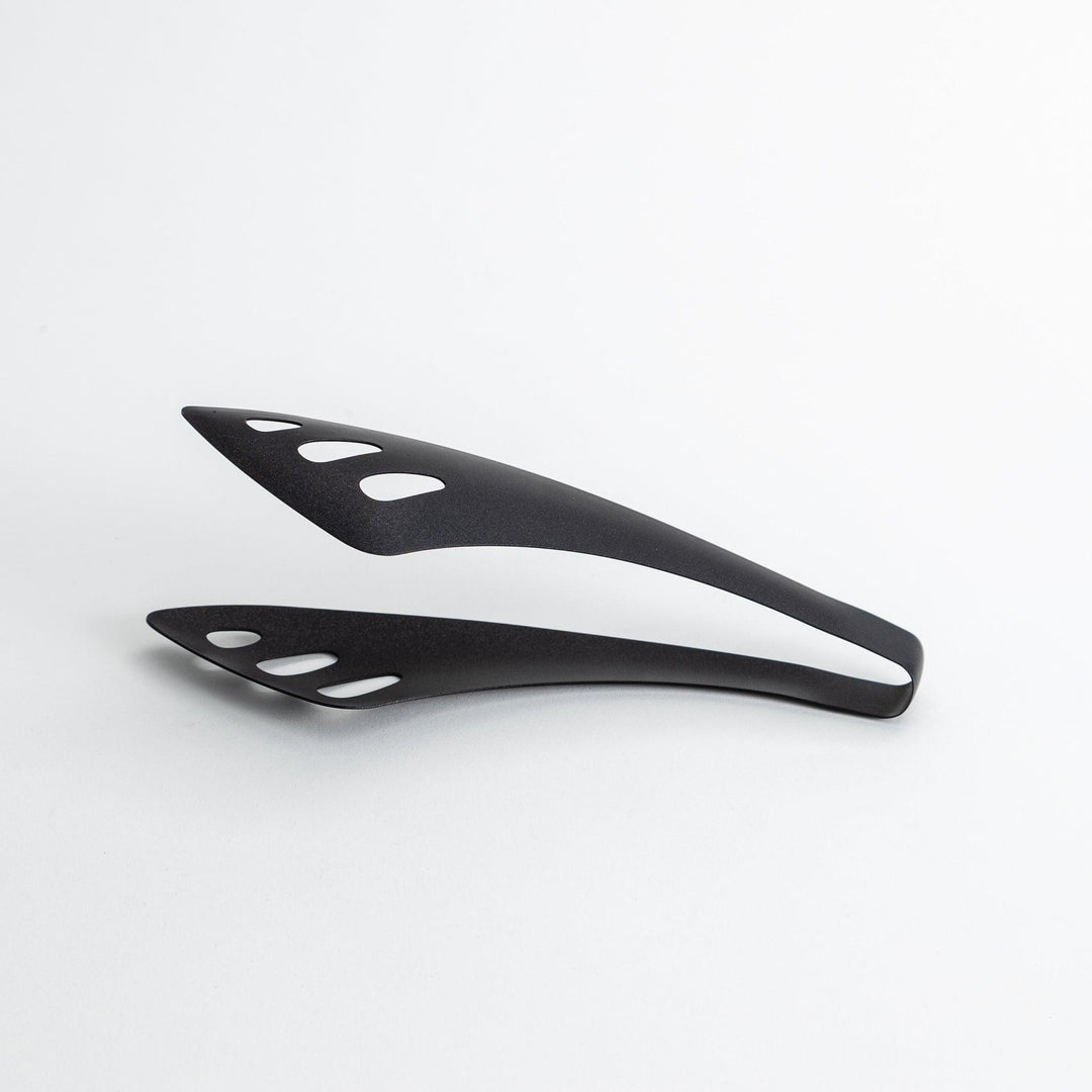 Matte black serving tongs with curved tips and a sturdy design, featuring small holes for draining or straining when serving.