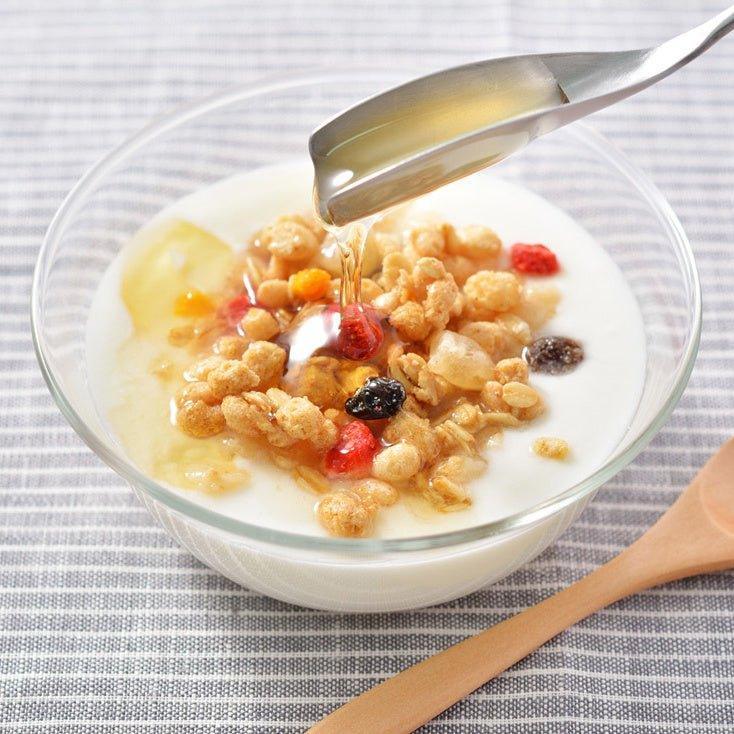 Long-handled stainless steel honey spoon with a uniquely shaped flat scoop