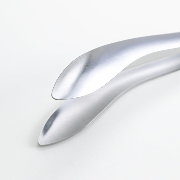 Smooth, curved stainless steel tongs with a minimalist design.