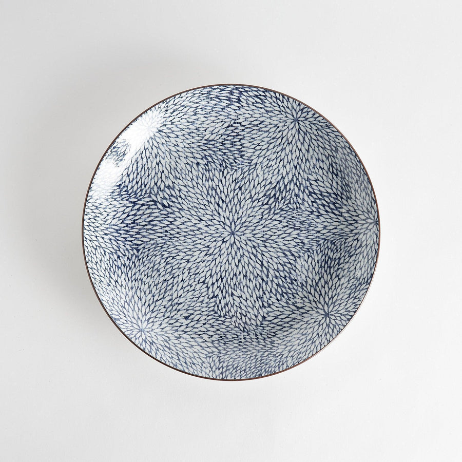 A round serving plate adorned with a detailed pattern of concentric blue dots creating a mesmerizing effect.