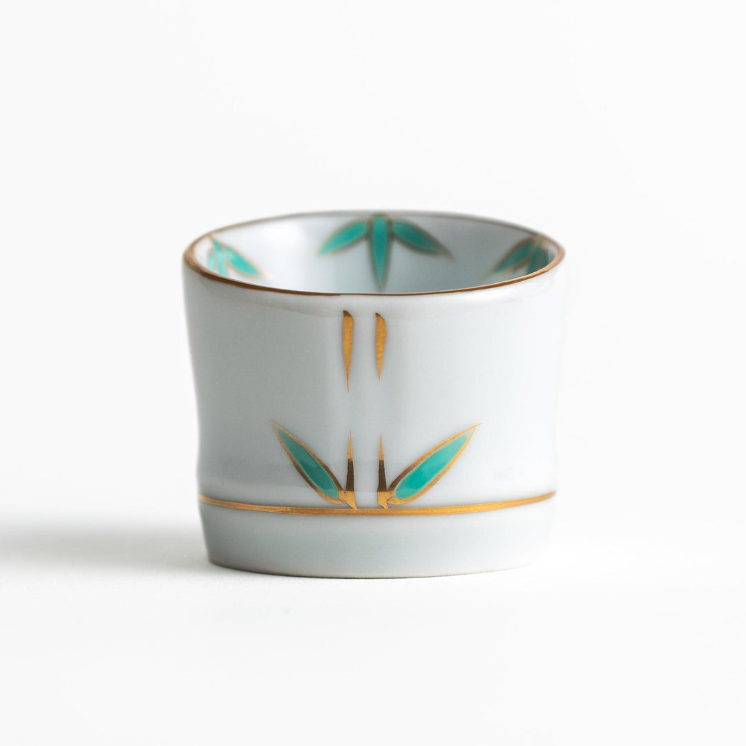 A small white bowl with a green bamboo leaf design and gold rim.