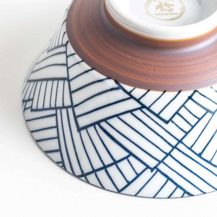 Basket weave patterned bowl with intricate blue geometric lines on a white background, featuring a brown base.