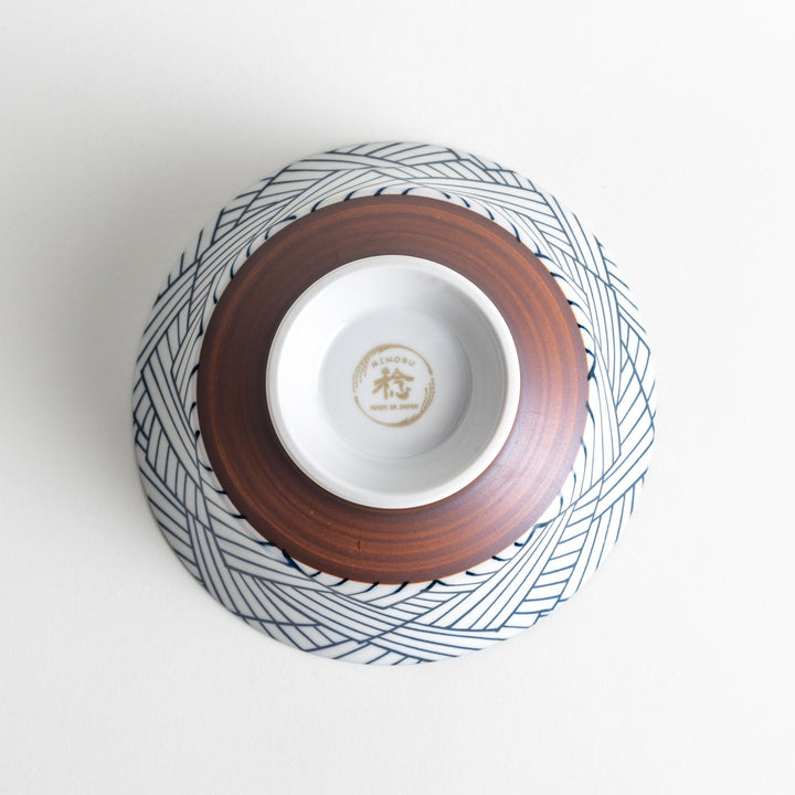 Basket weave patterned bowl with intricate blue geometric lines on a white background, featuring a brown base.