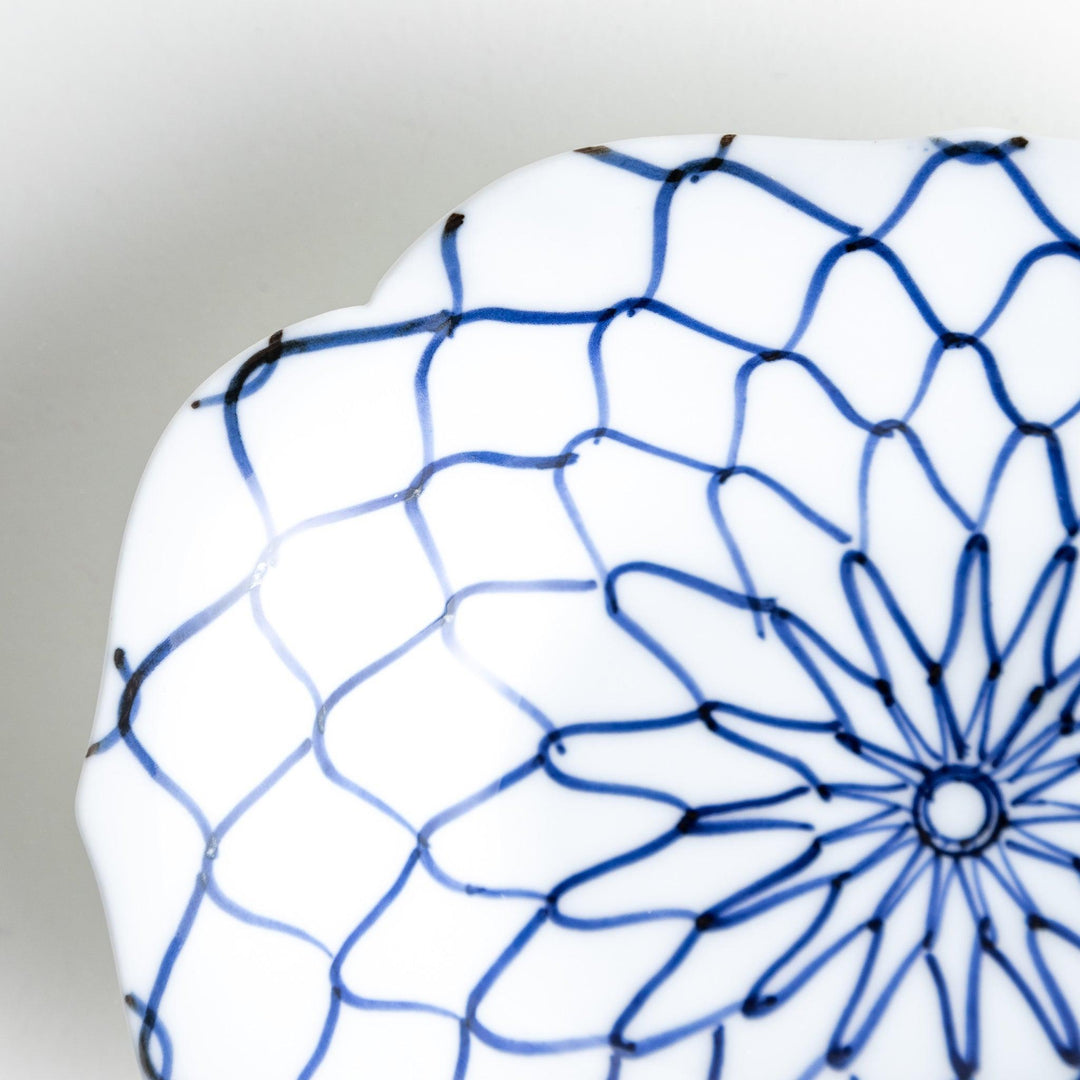 White dessert plate with a bowl shape featuring a blue or red net-like pattern