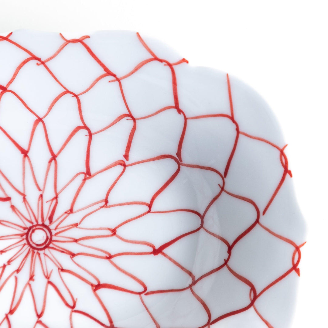 White dessert plate with a bowl shape featuring a blue or red net-like pattern