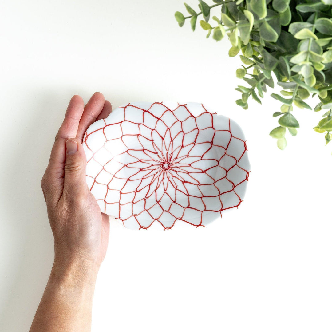 White dessert plate with a bowl shape featuring a blue or red net-like pattern