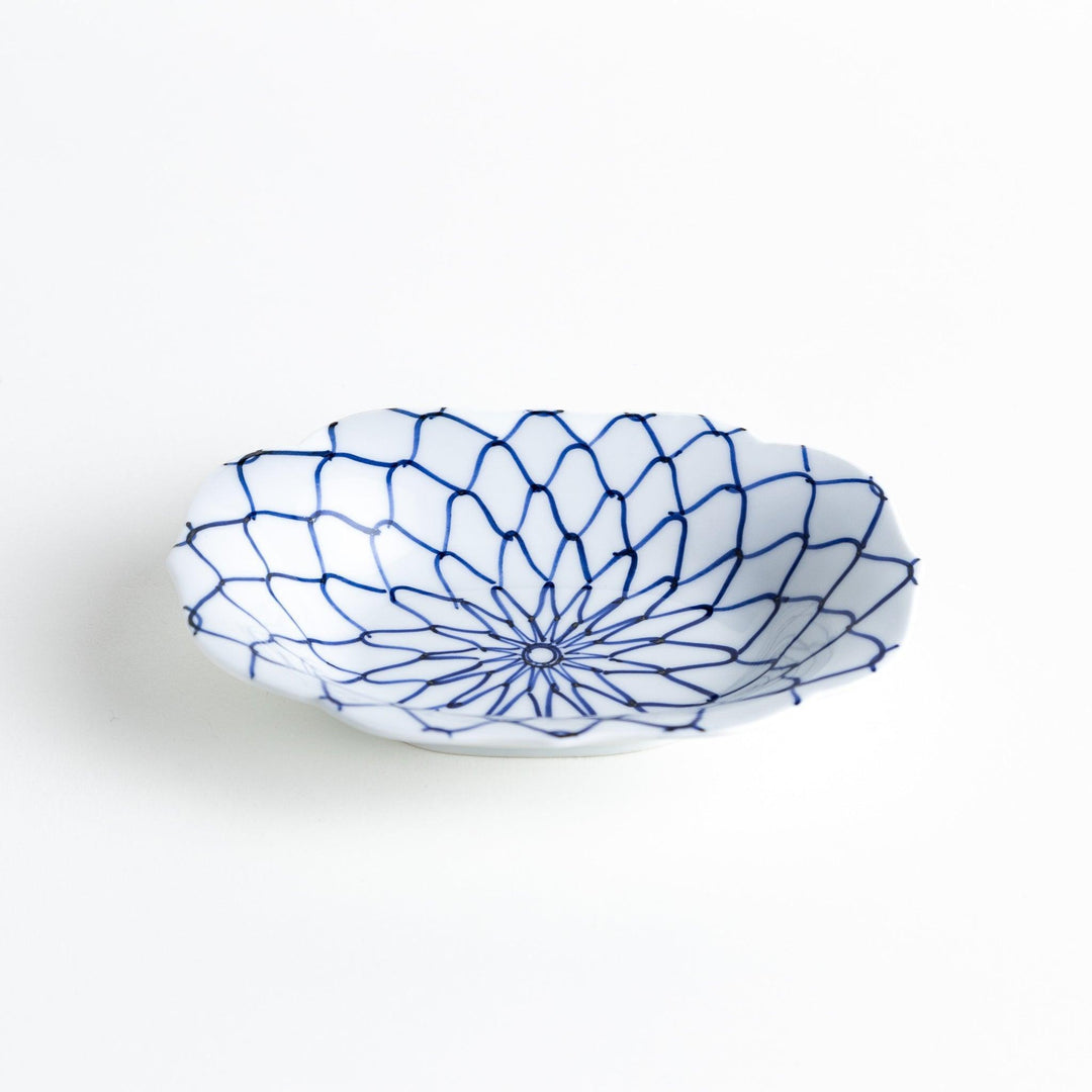 White dessert plate with a bowl shape featuring a blue or red net-like pattern