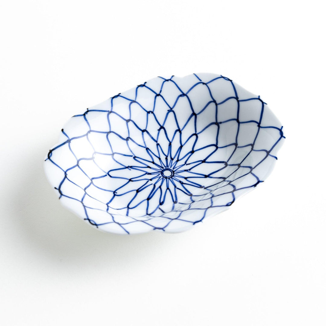 White dessert plate with a bowl shape featuring a blue or red net-like pattern