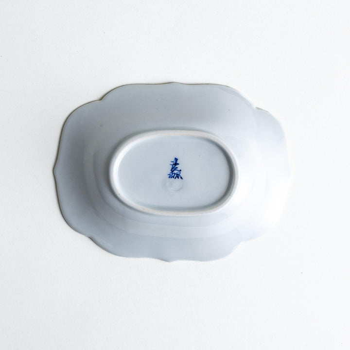 White dessert plate with a bowl shape featuring a blue or red net-like pattern