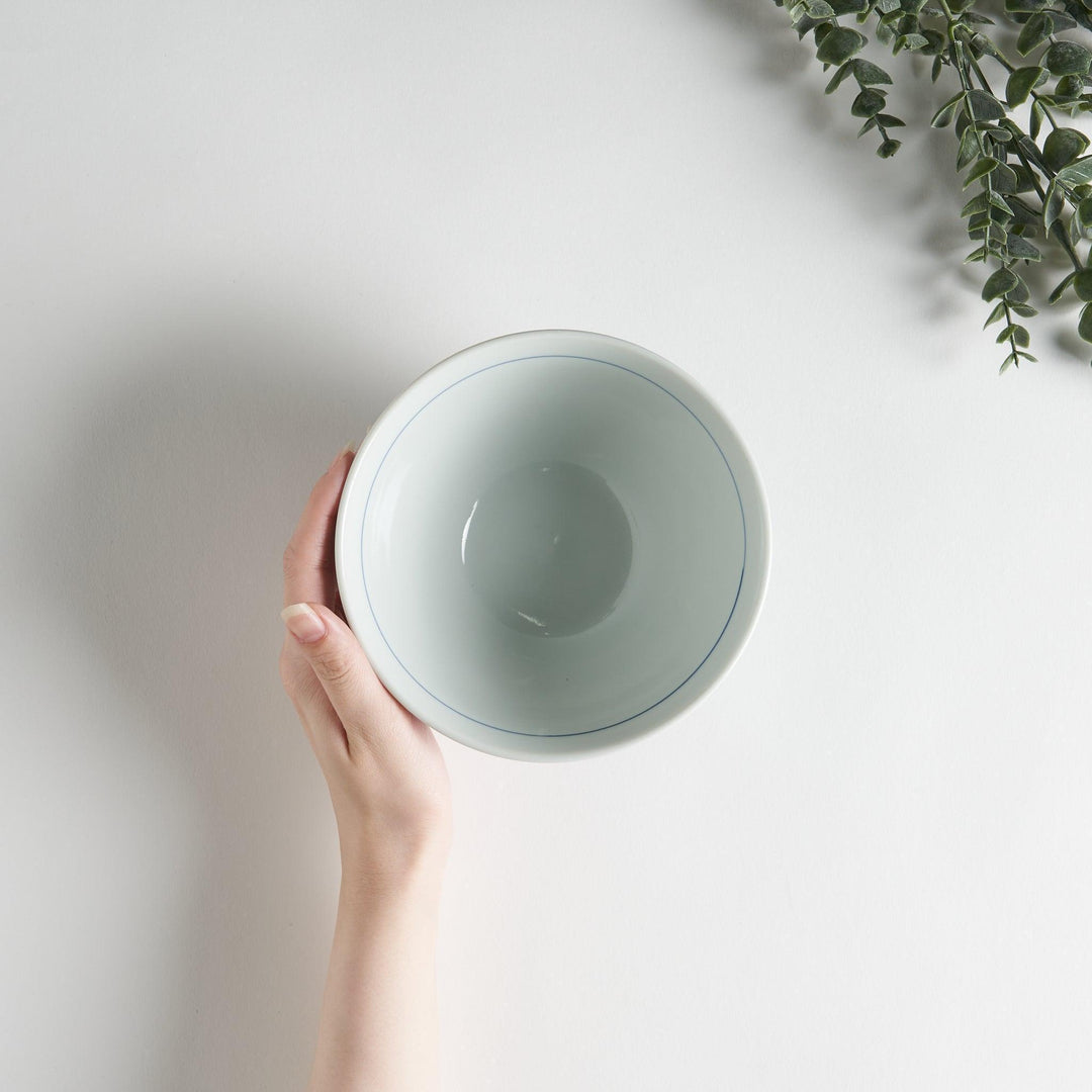 A white ceramic bowl with blue swirling patterns, traditional Japanese design.