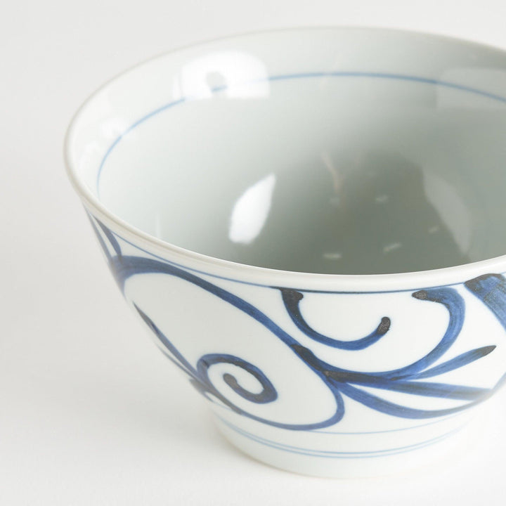 A white ceramic bowl with blue swirling patterns, traditional Japanese design.