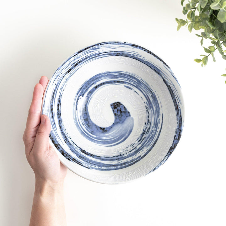 A large white bowl with a blue swirl pattern on the interior, featuring a smooth finish.