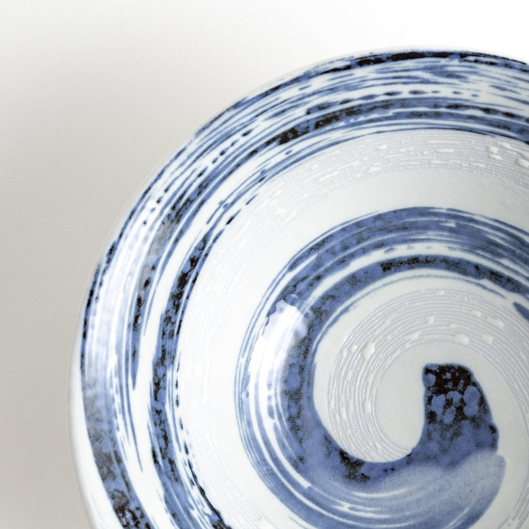 A large white bowl with a blue swirl pattern on the interior, featuring a smooth finish.