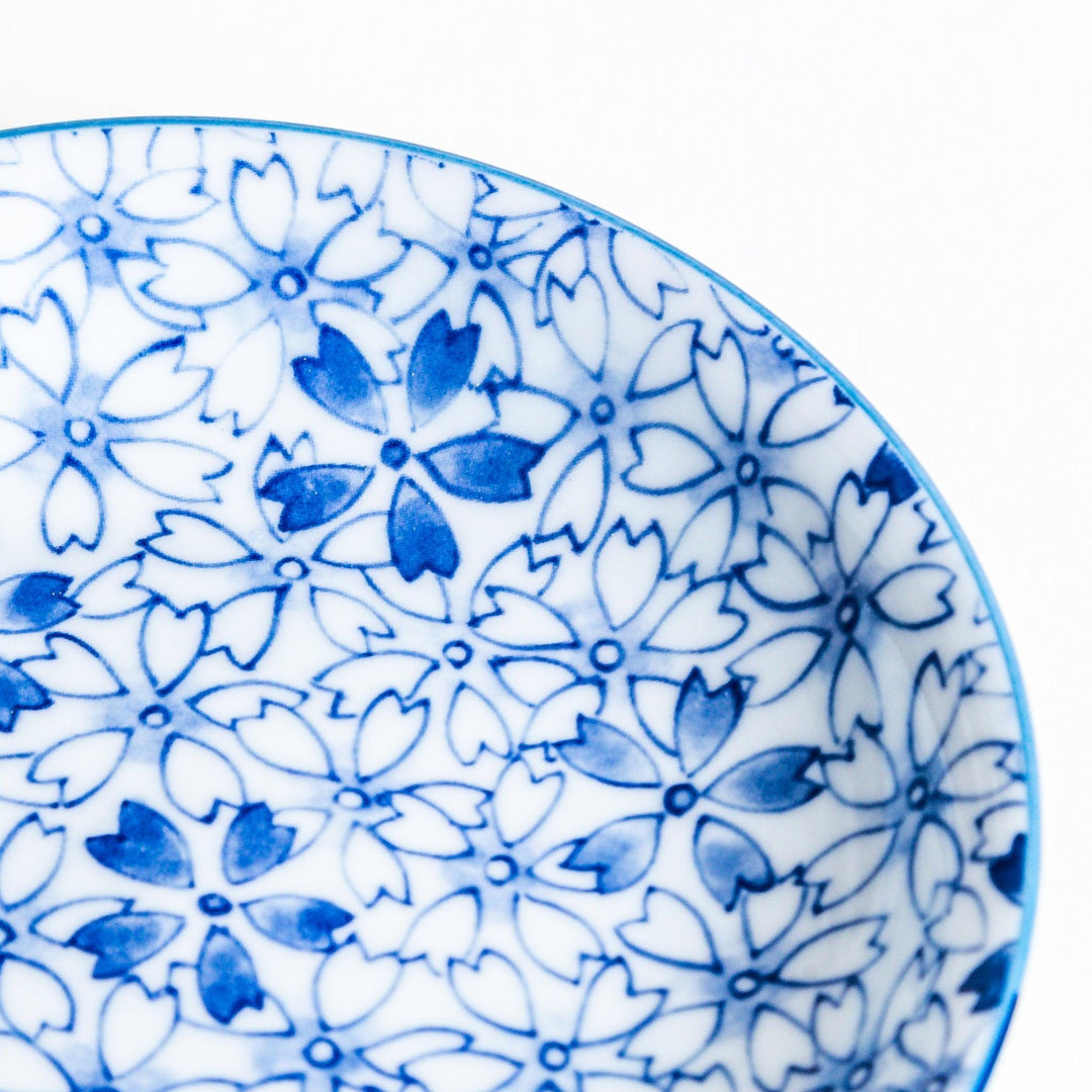 A dessert plate featuring a blue sakura (cherry blossom) pattern across its surface.