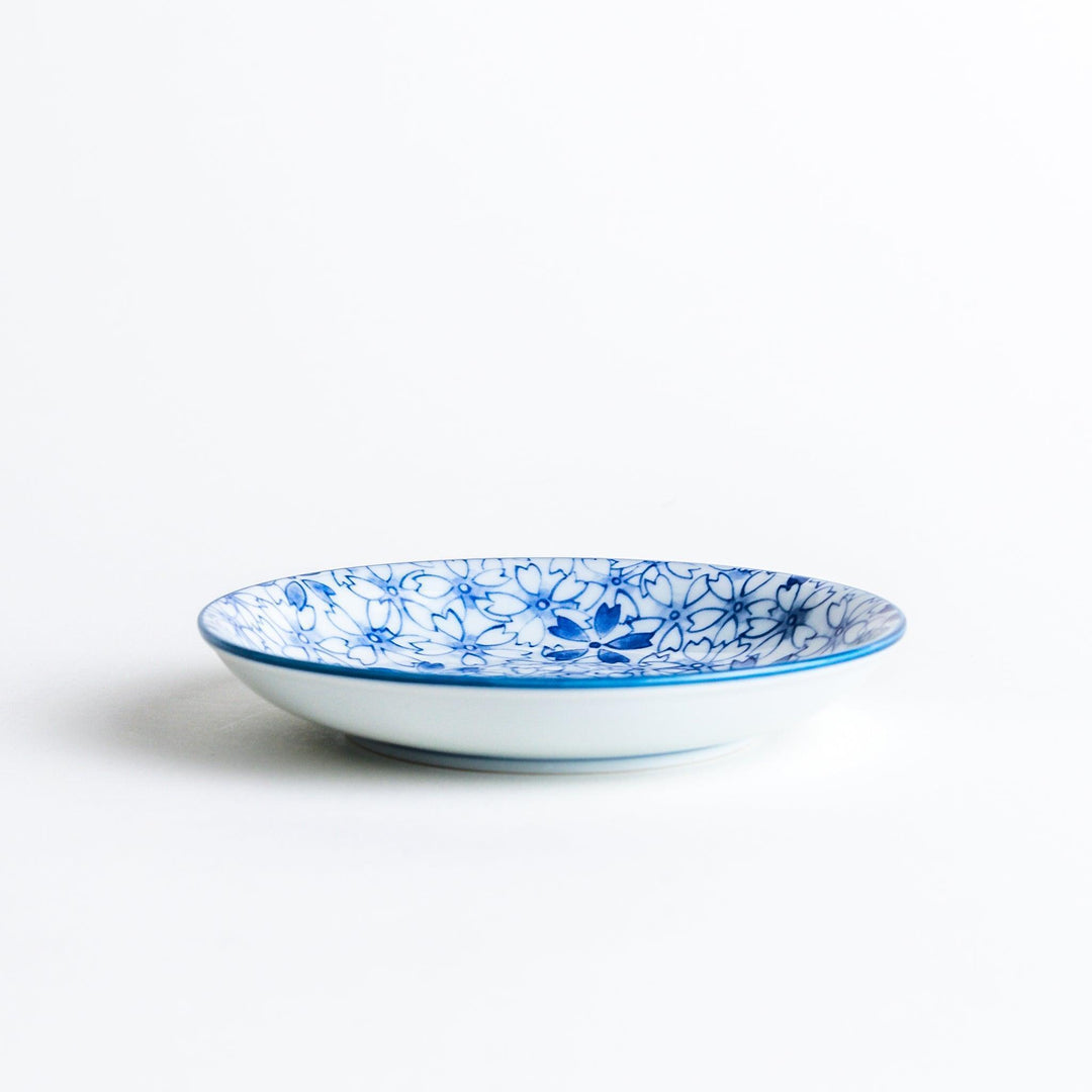 A dessert plate featuring a blue sakura (cherry blossom) pattern across its surface.