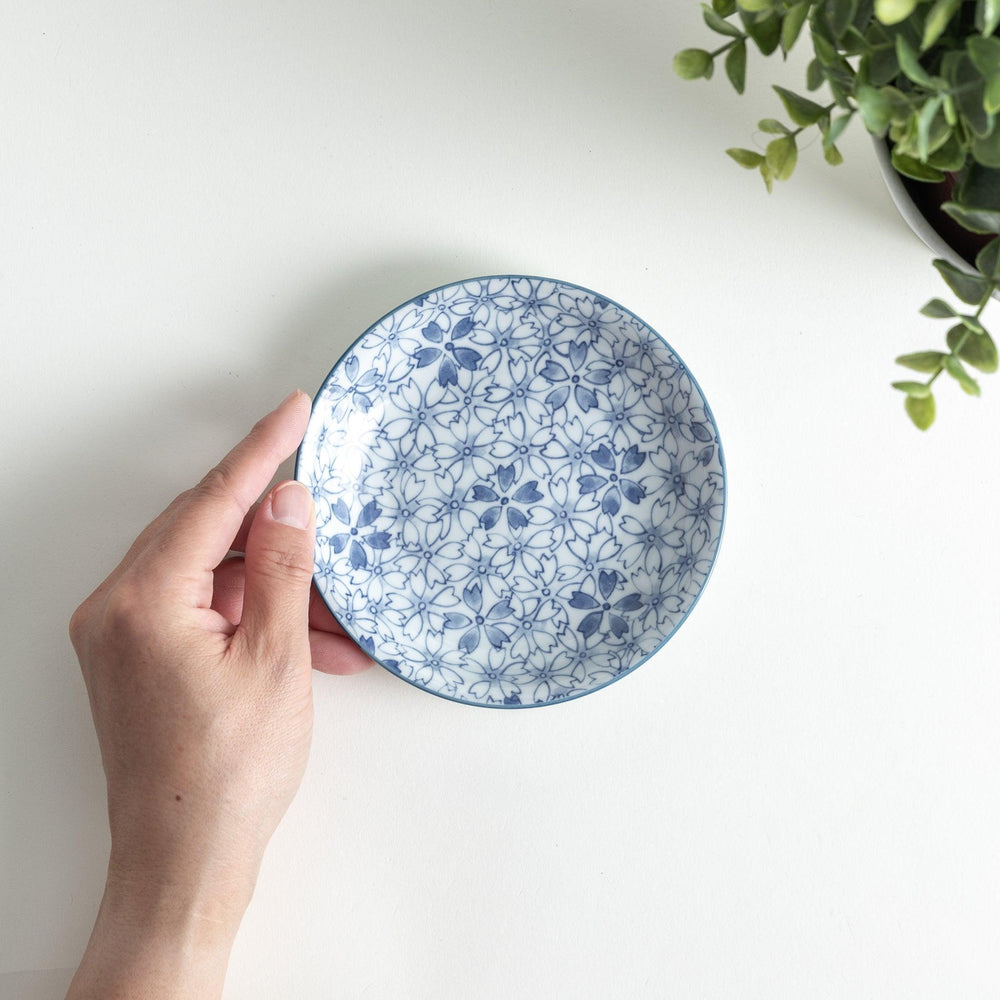 A dessert plate featuring a blue sakura (cherry blossom) pattern across its surface.