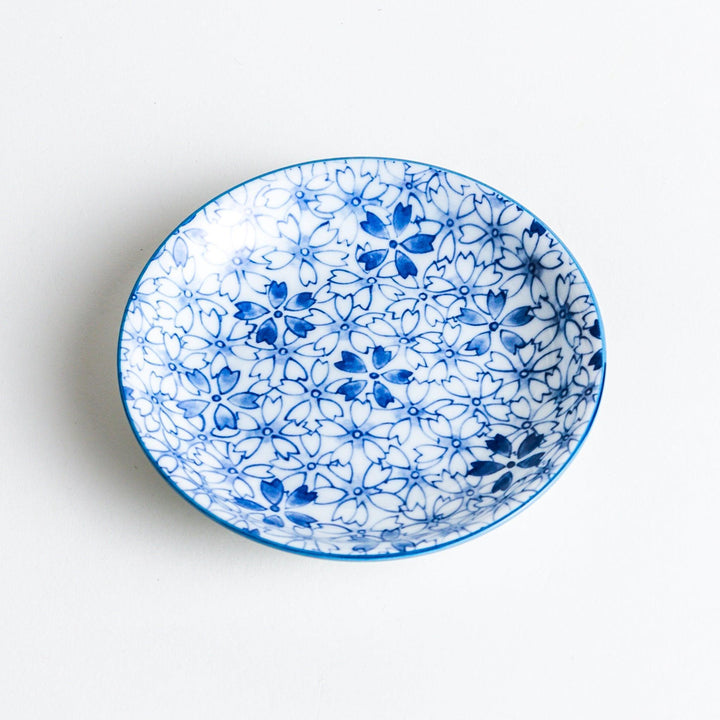 A dessert plate featuring a blue sakura (cherry blossom) pattern across its surface.