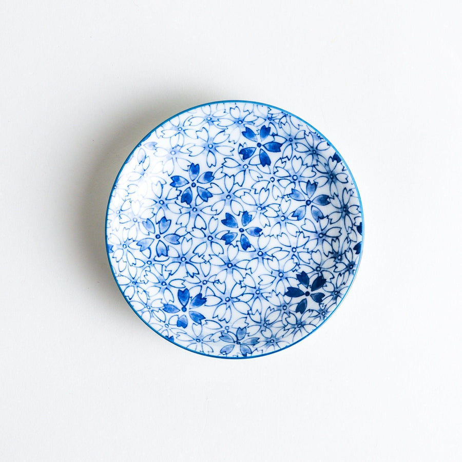 A dessert plate featuring a blue sakura (cherry blossom) pattern across its surface.