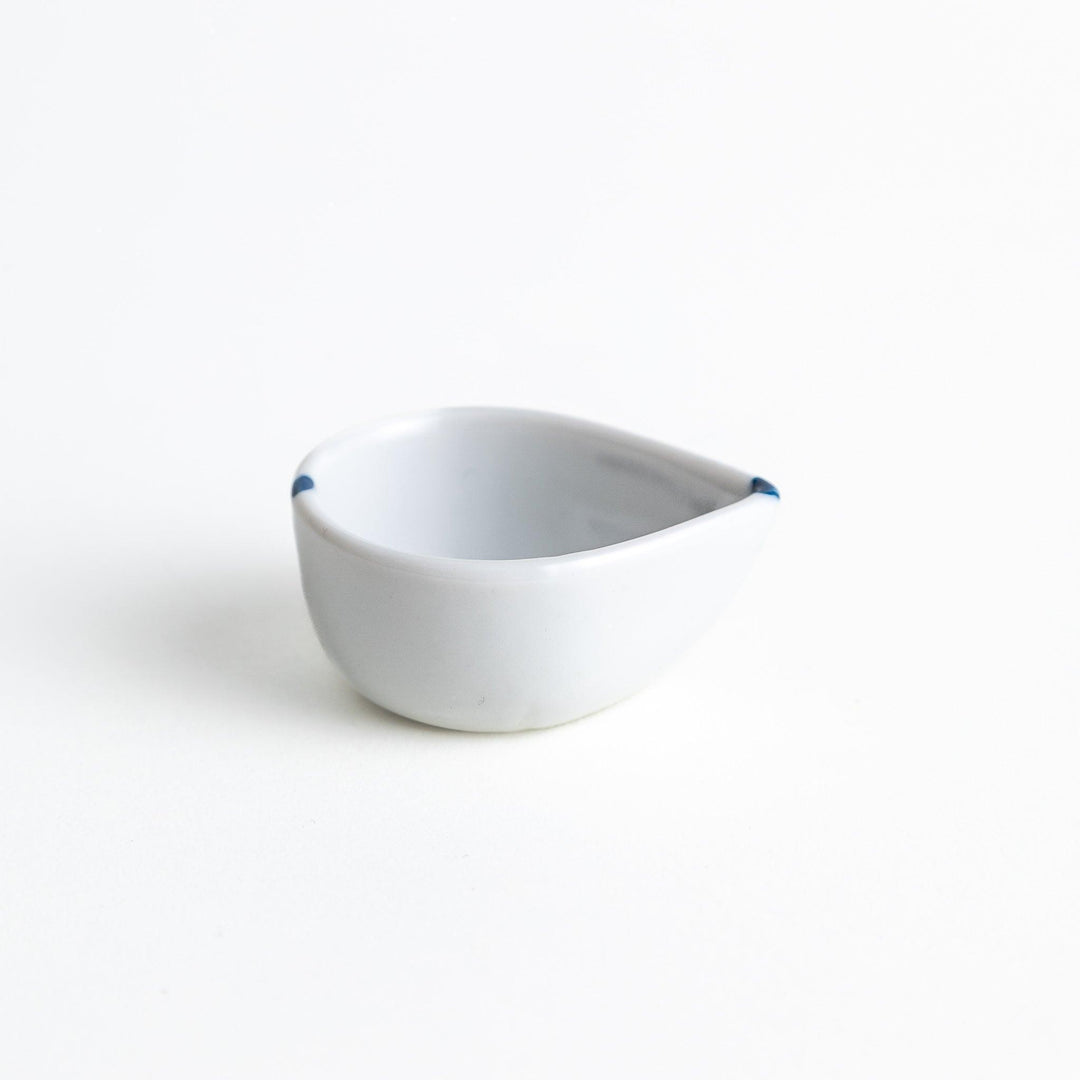 A small, curved condiment bowl with minimal blue dot accents.