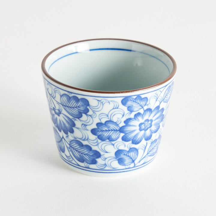 A small cylindrical cup with a bold blue flower pattern on a white base.