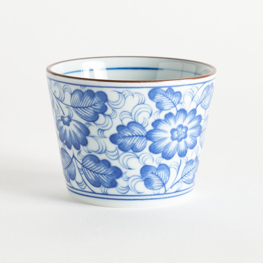 A small cylindrical cup with a bold blue flower pattern on a white base.