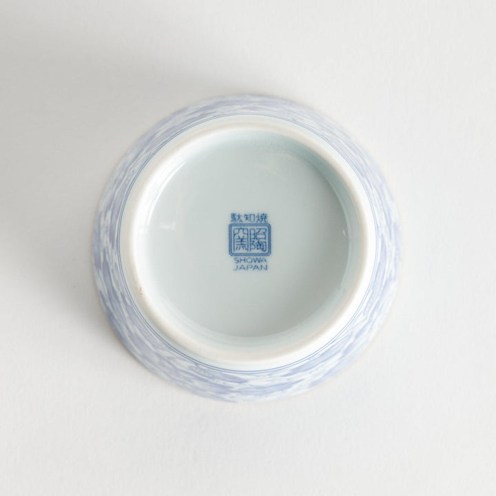 A small cylindrical cup with a bold blue flower pattern on a white base.