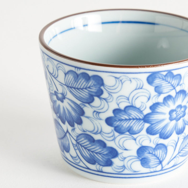 A small cylindrical cup with a bold blue flower pattern on a white base.