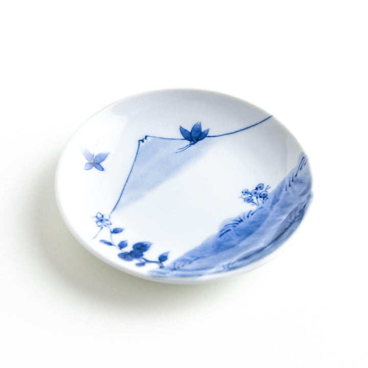 Round plate with a blue and white Mount Fuji and butterfly scene.