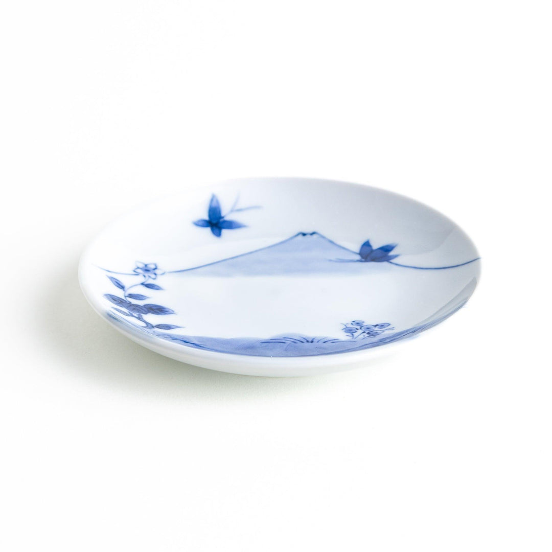 Round plate with a blue and white Mount Fuji and butterfly scene.