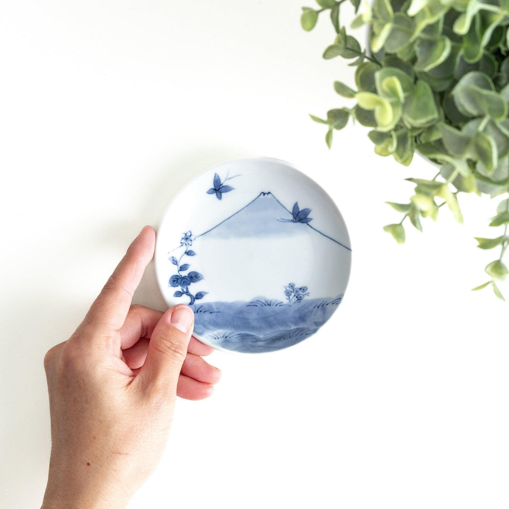 Round plate with a blue and white Mount Fuji and butterfly scene.