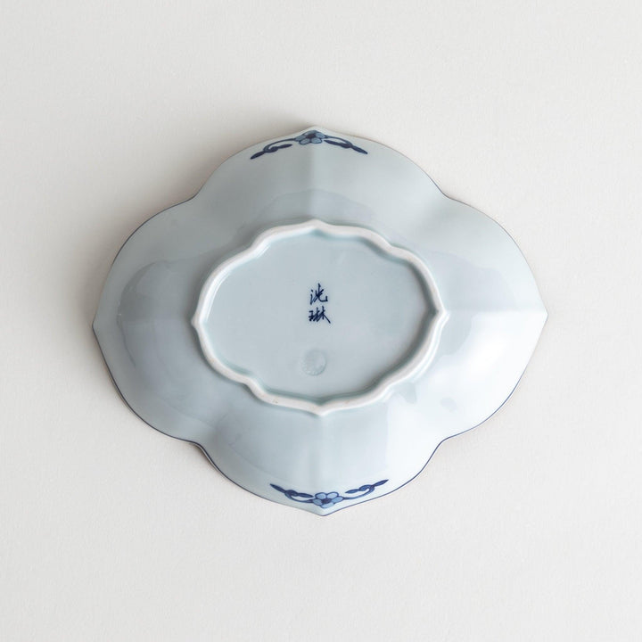 A ceramic bowl with a cloud-like shape and a blue patterned rim.