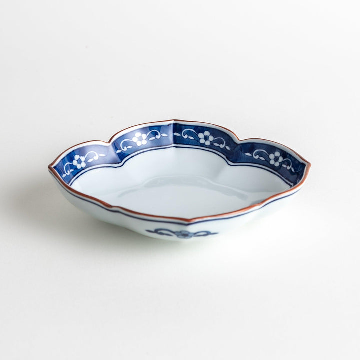 A ceramic bowl with a cloud-like shape and a blue patterned rim.