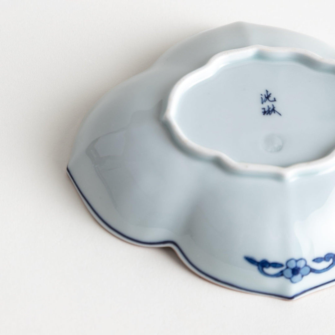 A ceramic bowl with a cloud-like shape and a blue patterned rim.