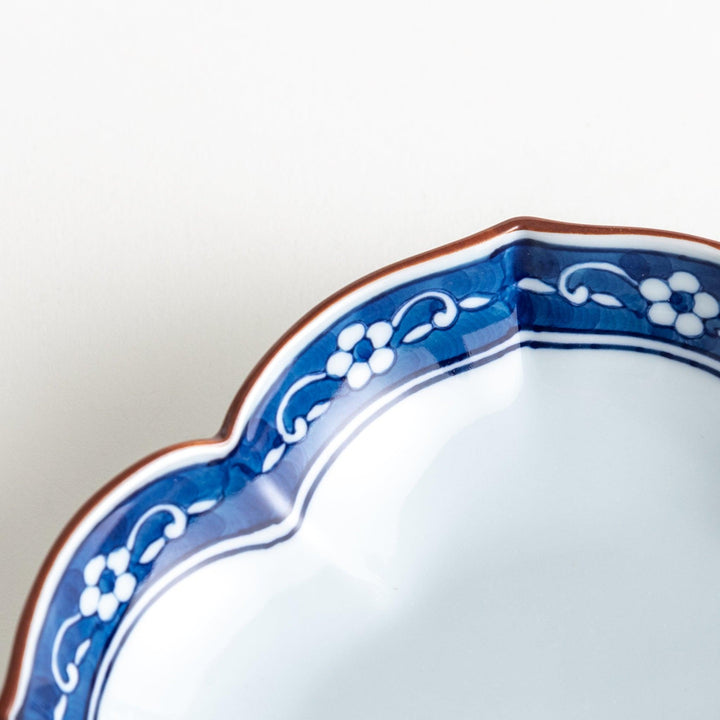 A ceramic bowl with a cloud-like shape and a blue patterned rim.