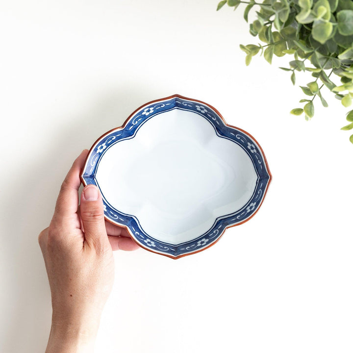 A ceramic bowl with a cloud-like shape and a blue patterned rim.