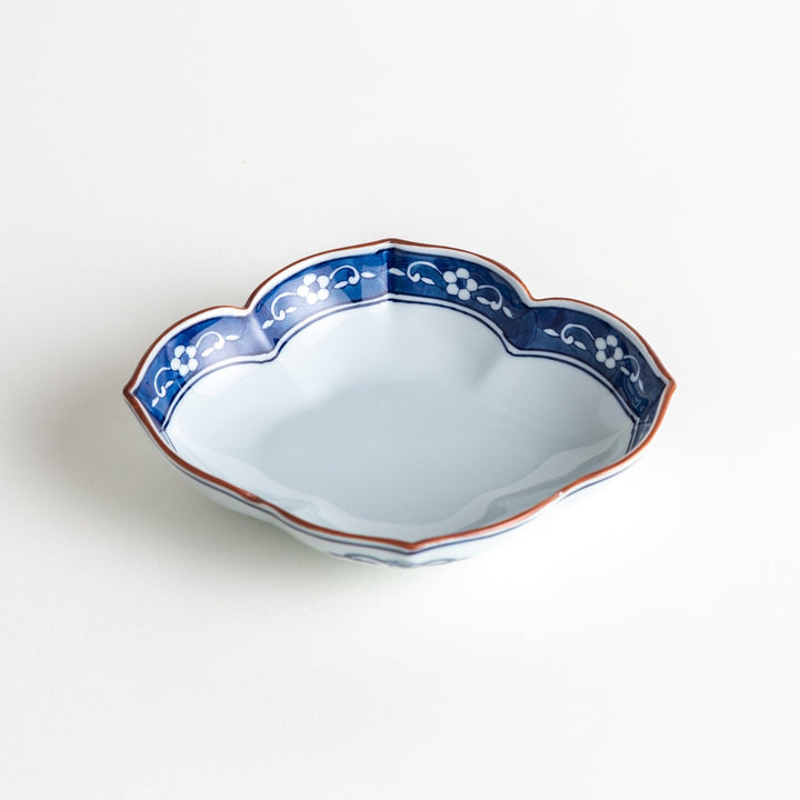 A ceramic bowl with a cloud-like shape and a blue patterned rim.